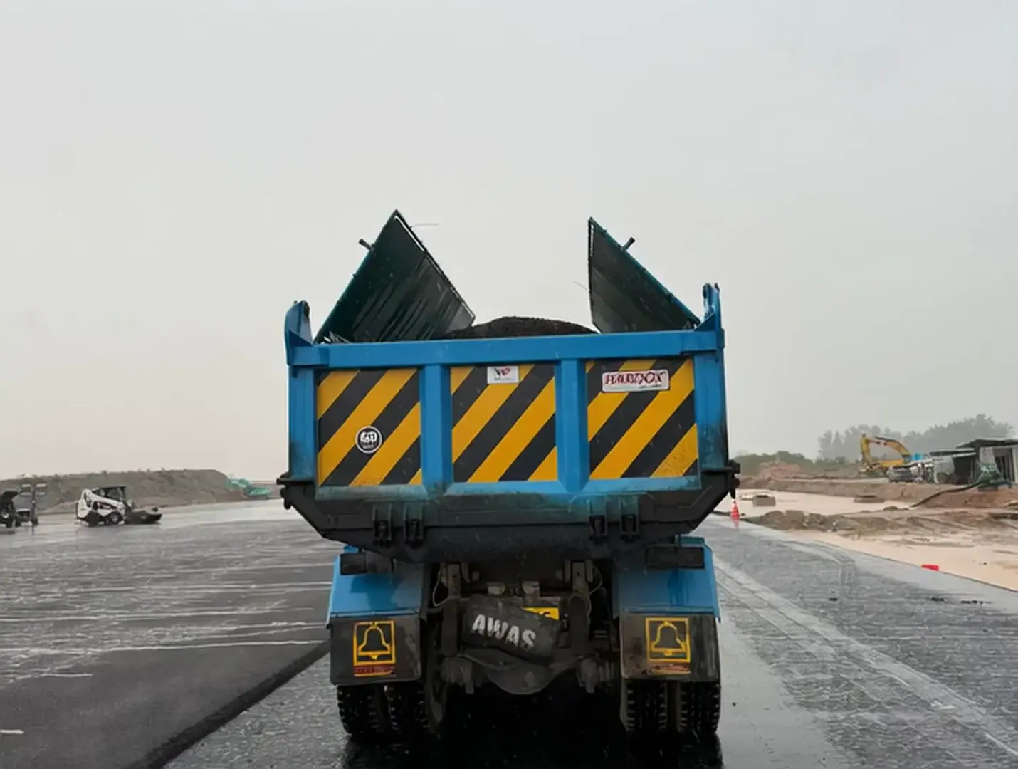 Dump truck delivering aggregates at sunrise
